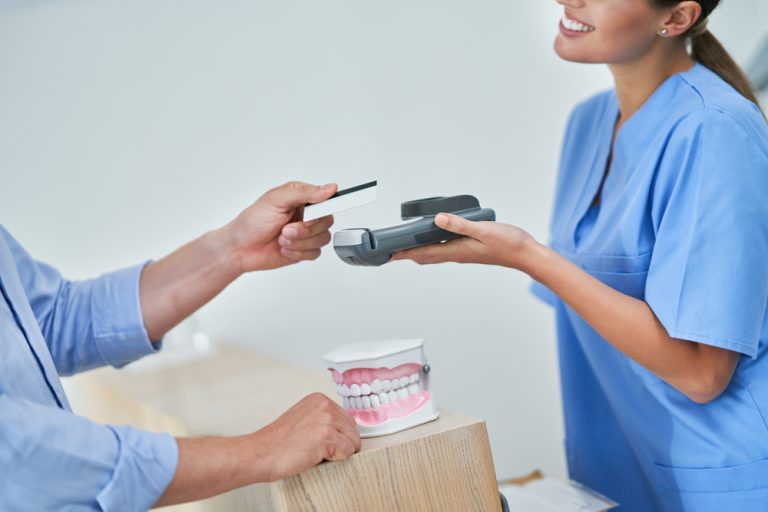 Patient,Paying,For,Dental,Visit,In,Clinic