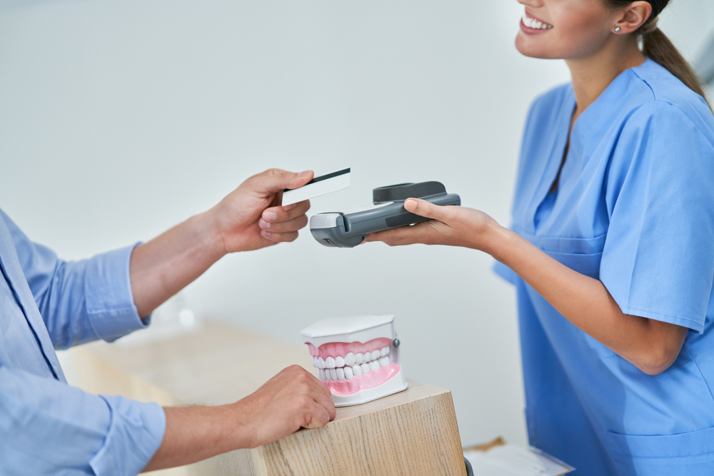 Patient,Paying,For,Dental,Visit,In,Clinic