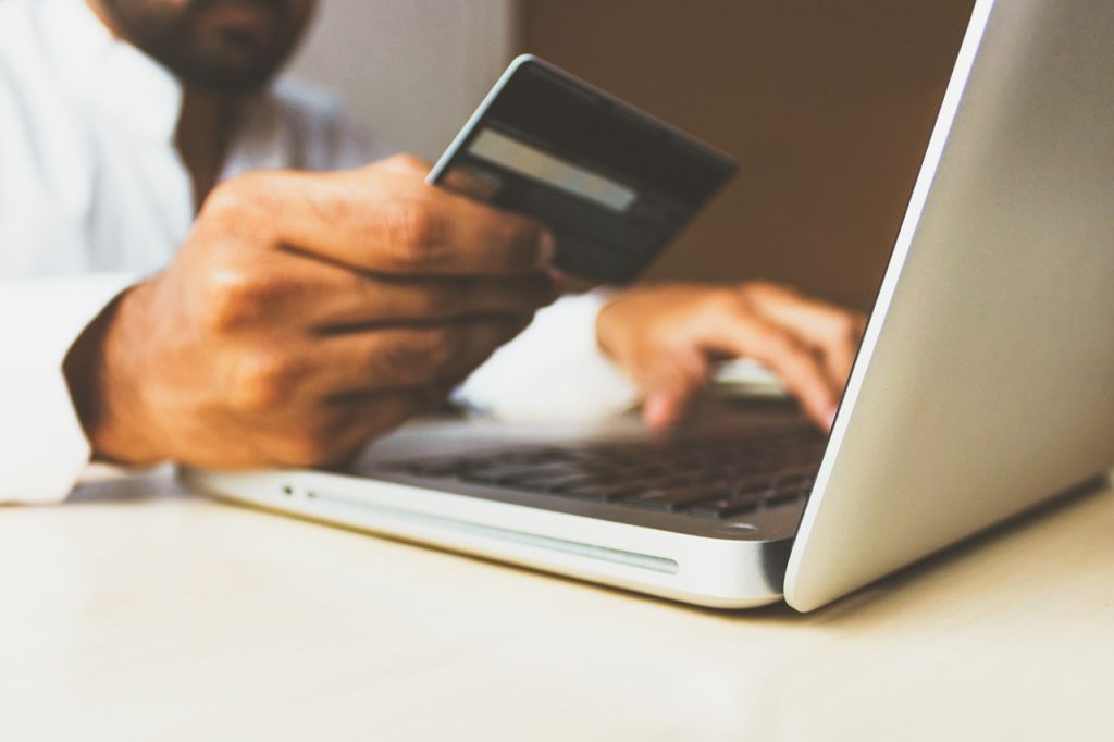 person inputting their credit card into an online payment on their laptop